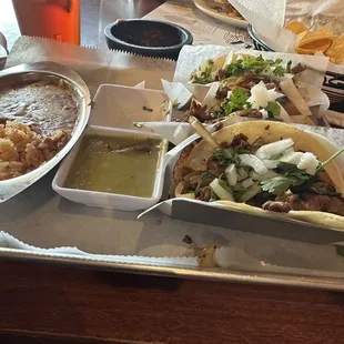 Mexican taco meal with mini tortillas served with tiny scoop of rice and beans.
