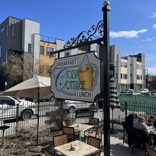 people sitting at tables outside a cafe