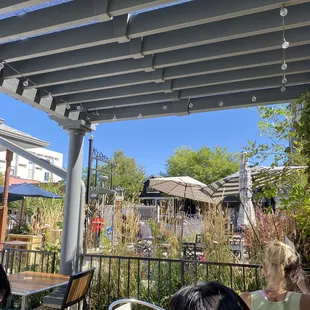 a view of a patio with tables and umbrellas