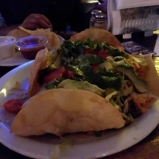 a plate of tacos with a side of salsa