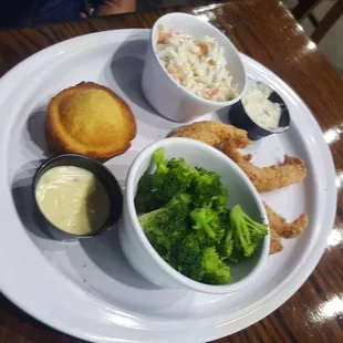 Catfish, coleslaw, broccoli with cheese sauce on the side and a corn muffin.