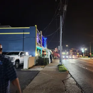 a man walking down a street at night