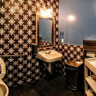 a bathroom with a toilet, sink and mirror