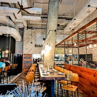 a view of a dining area with a bar and several people sitting at tables