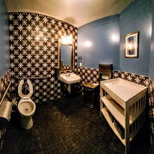 a bathroom with a toilet, sink, and mirror
