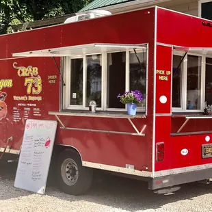 a red food truck parked in front of a house