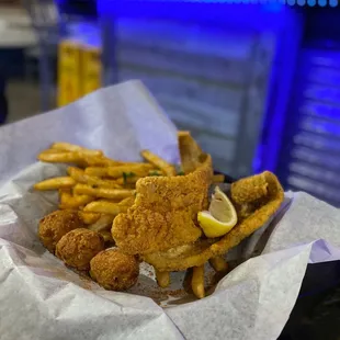 a basket of fried fish and fries