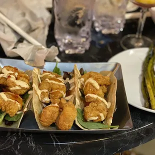 a plate of fish tacos and asparagus