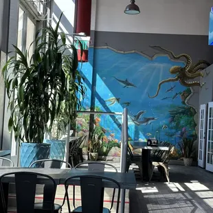 a restaurant with a mural on the wall