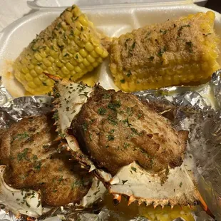 a plate of crab cakes and corn on the cob