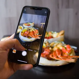 a person taking a picture of a plate of food