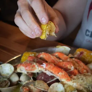 a person holding a piece of crab and clamsel