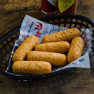 a basket of crab nuggies with lemon wedges