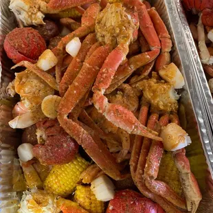 crab legs, corn, potatoes, and corn on the cob