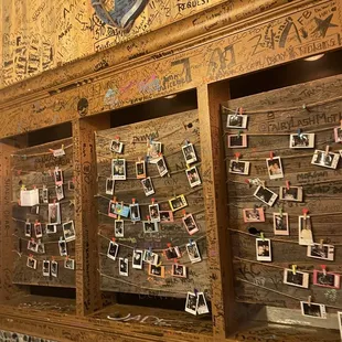 a wooden wall covered in photos