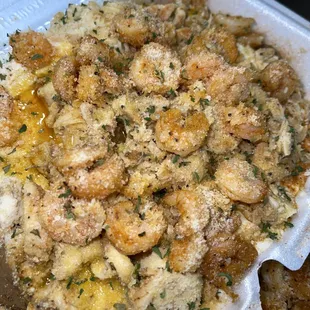 a close up of a crab and shrimp dish in a styrofoam container