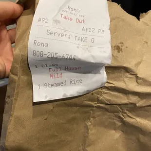 a person holding a piece of paper with a receipt on it