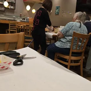 Waitress helping peel an elderly couples food.