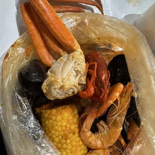 the ayce first bag consisting of shrimps, crawfish, mussels, mini scallop and 1 cluster of snow crabs and additional corn
