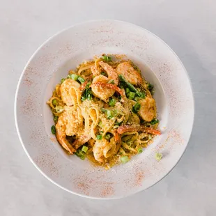 a bowl of noodles with shrimp and vegetables