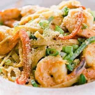 a plate of pasta with shrimp and vegetables