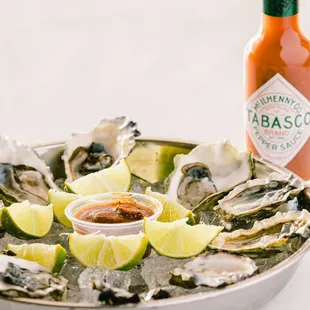 a plate of oysters and a bottle of tabasco sauce