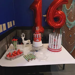 a table with a cake and balloons