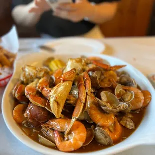 a plate of clams with a woman in the background