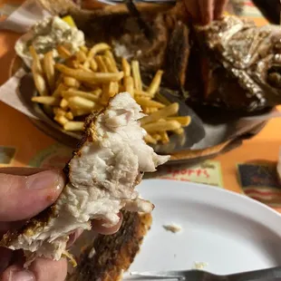 a hand holding a half eaten crab