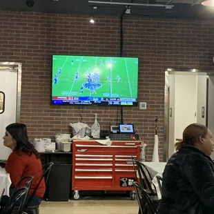 people sitting at tables watching tv