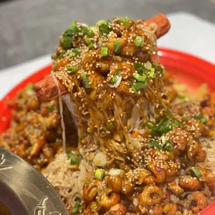 a plate of food with noodles and chopsticks