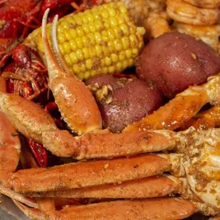 crab legs, corn, potatoes, and corn on the cob