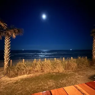 a full moon over the ocean