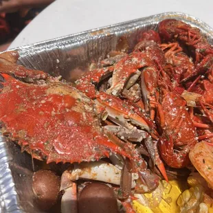 a tray of cooked crabs and corn
