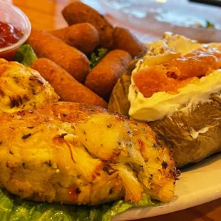 Soft shell crab cake dinner with hush puppies and baked potato fully loaded.