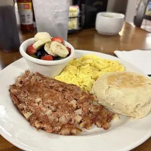Corned beef hash with scrambled eggs side of fruit and biscuit