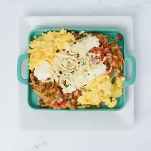 "Indulge in our Sausage Italian Skillet: Italian sausage, creamy ricotta, gooey mozzarella, green peppers, onions, and tomatoes all sizzling