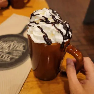 a hand holding a cup of hot chocolate
