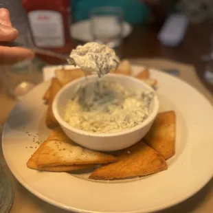 a bowl of dip and crackers on a plate