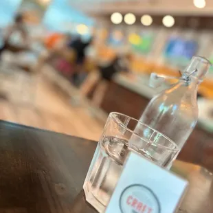 a bottle of water and a glass on a table