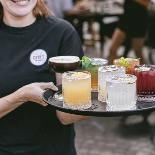 a woman holding a tray of drinks