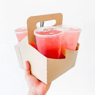 a hand holding a box of drinks