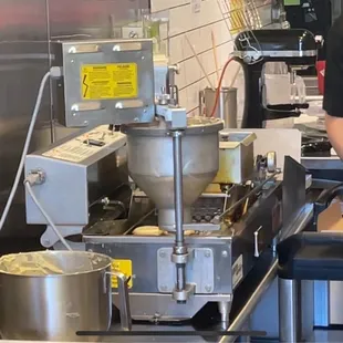 Donut machine dropping fresh donut batter