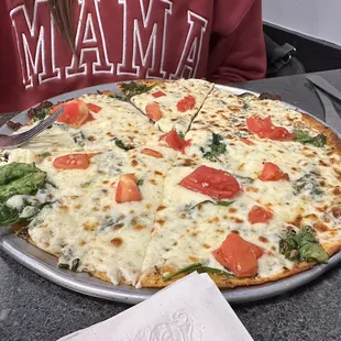 a pizza with tomatoes and spinach
