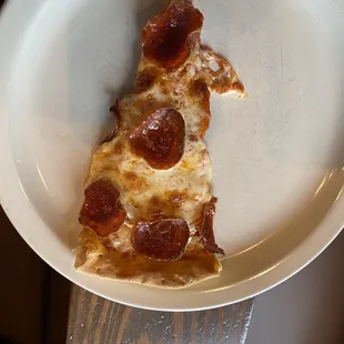 a slice of pepperoni pizza on a plate