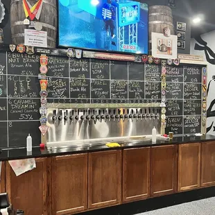 a chalkboard wall with beer taps