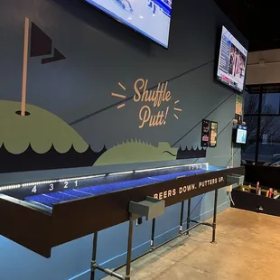 a shuffle table with a tv in the background