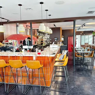 a bar with yellow chairs