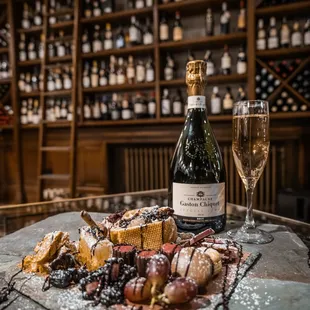 a plate of cheese, crackers, and a bottle of wine