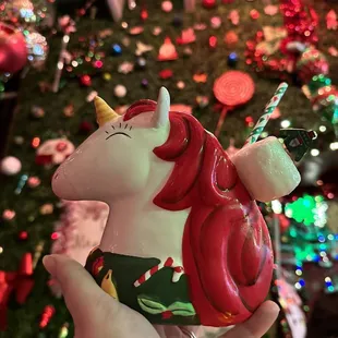 a hand holding a unicorn ornament